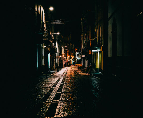 Dunkle Straße, die durch ganz wenig Licht beleuchtet wird