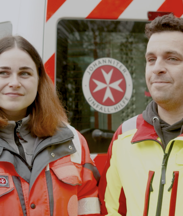 Mann und Frau mit Rettungsweste lächeln in die Kamera