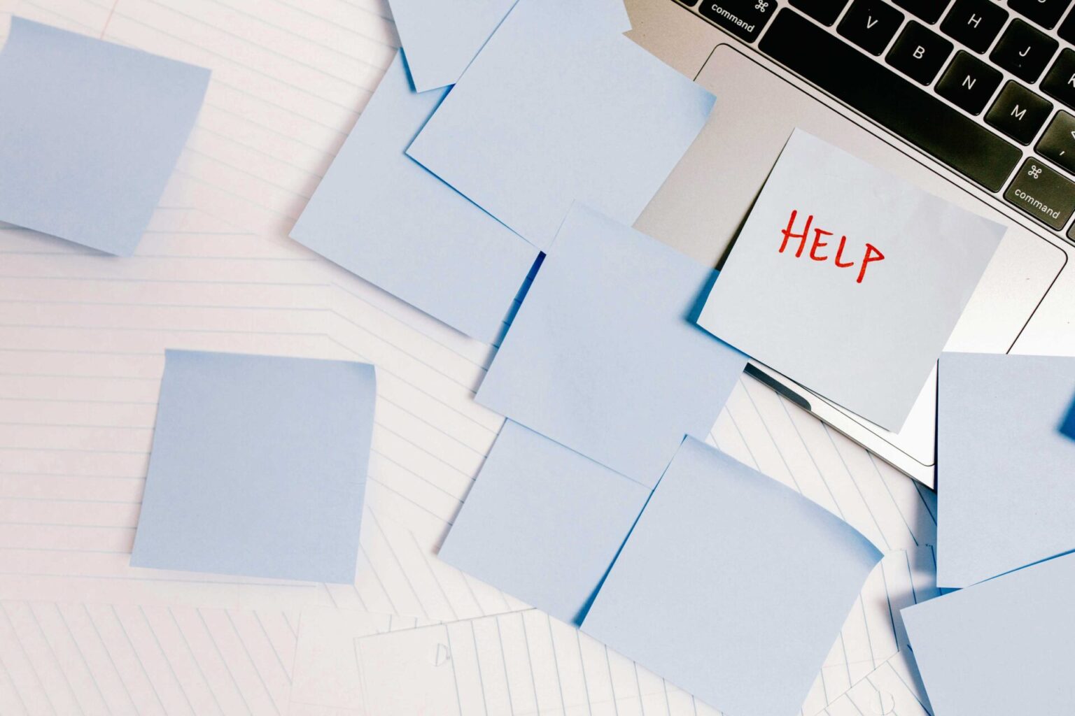 Viele Post-It's, die auf einem Laptop kleben. Auf einem steht
